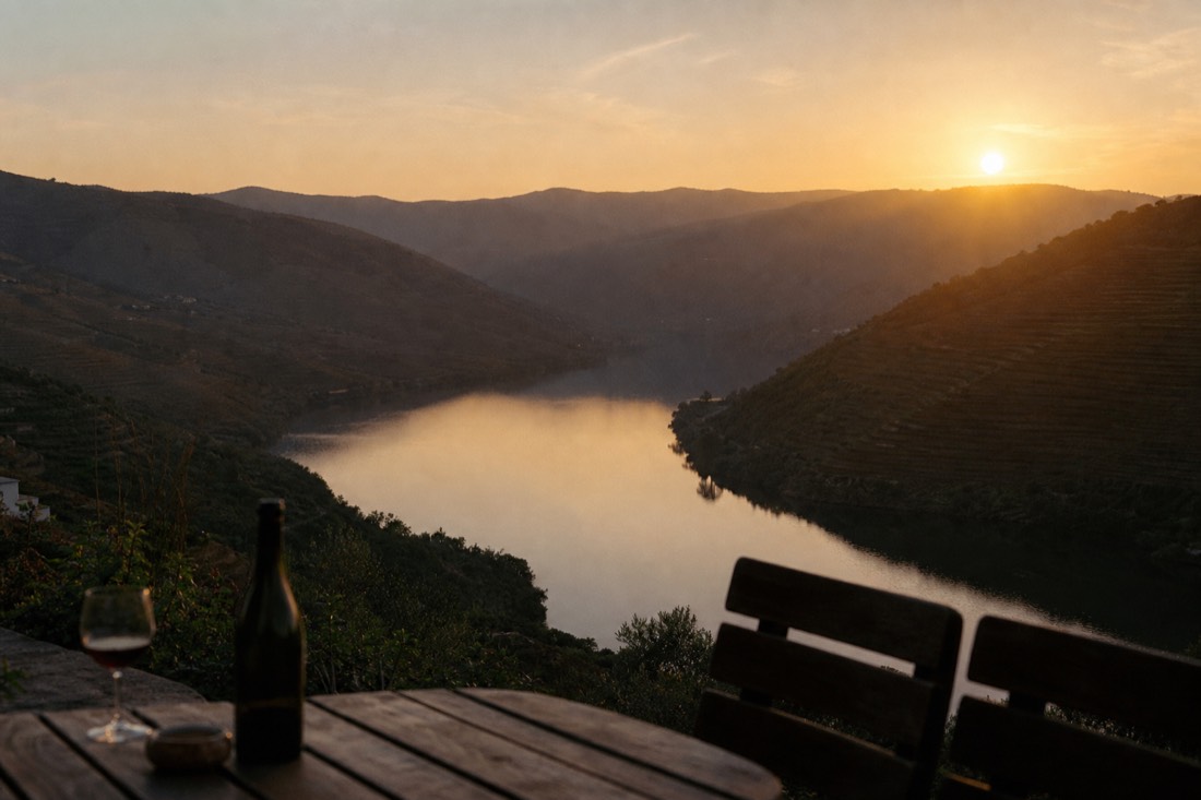 Golden evening light over the Douro river bend with terraced hills in shadow and calm water