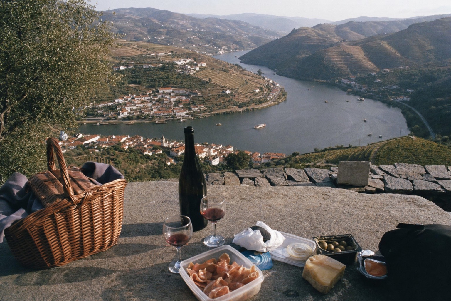 Pinhao river bend seen from above with terraced vineyards wrapping the hills and boats small on the water