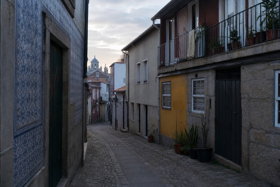 Quiet Porto street at dawn with tiled facades and soft light, the city not yet awake