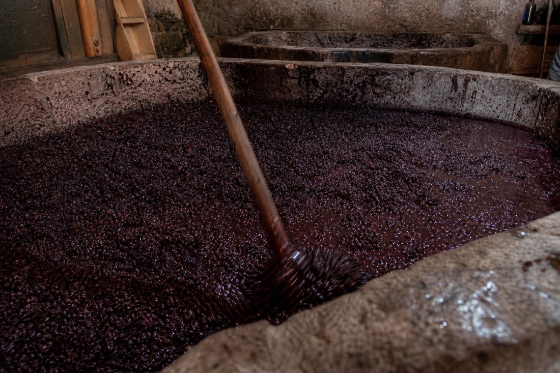 Shallow granite lagar tank filled with dark crushed grapes in a traditional Douro winery