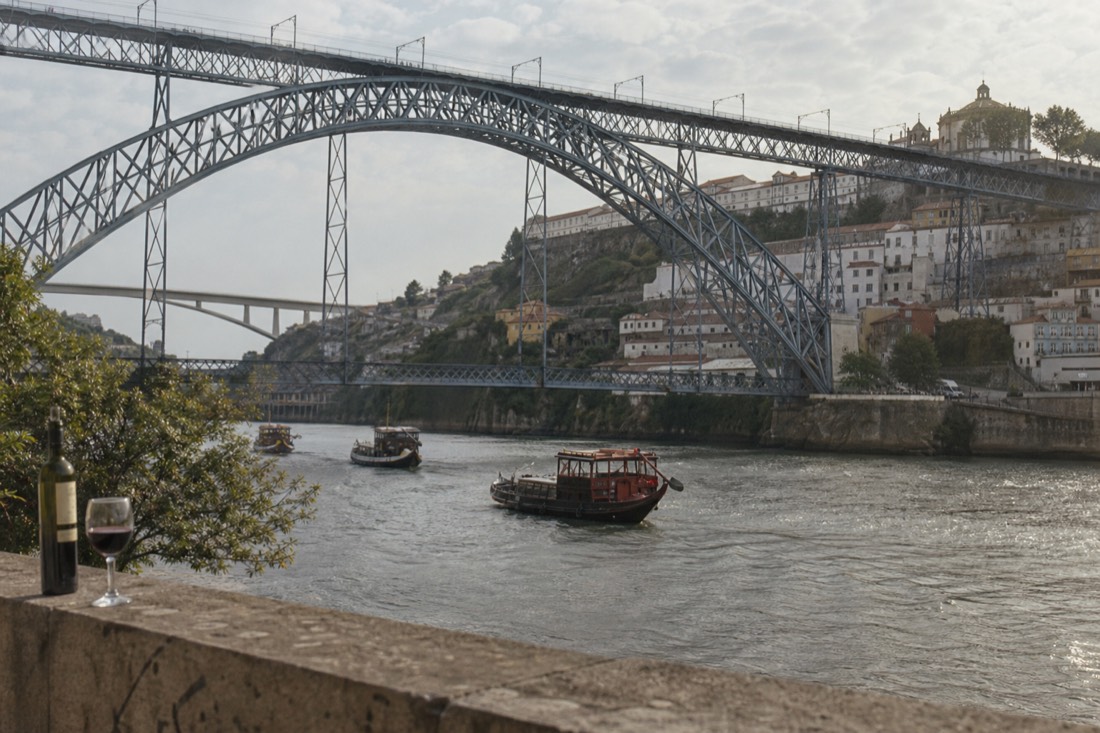 Iron arch bridge spanning the Douro between Porto and Gaia with small cruise boats on the city river