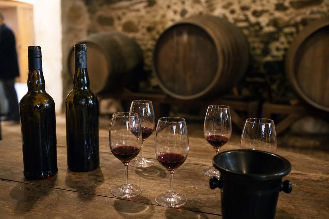 Small tasting table set with Port wine glasses inside a stone quinta cellar in the Douro Valley