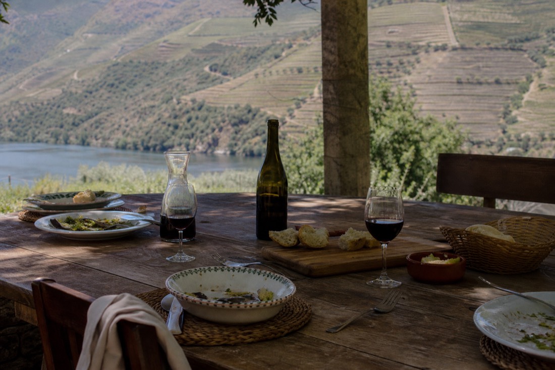 A rustic Douro lunch table set on a shaded quinta terrace overlooking the vineyards