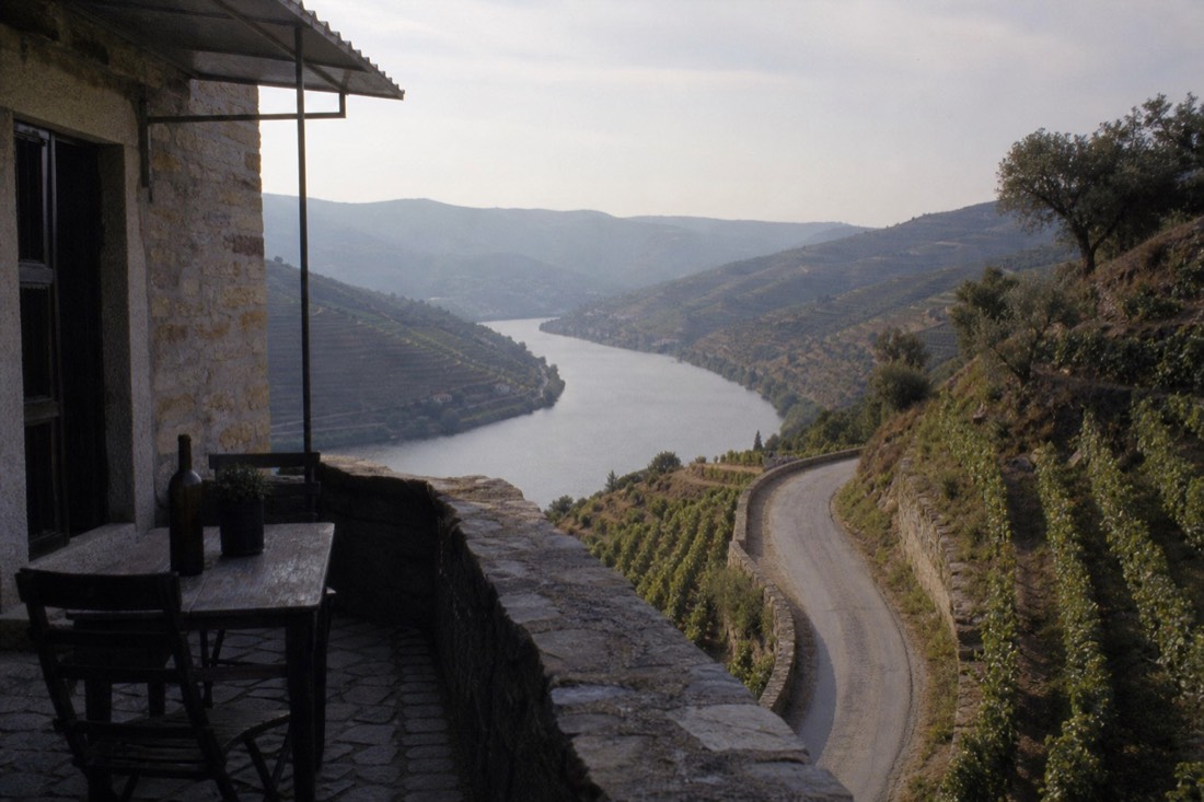 Winding road climbing above the Douro River between steep terraced vineyard slopes