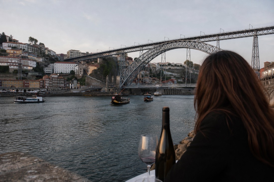 Iron arch bridge spanning the Douro between Porto and Gaia with cruise boats on the city river