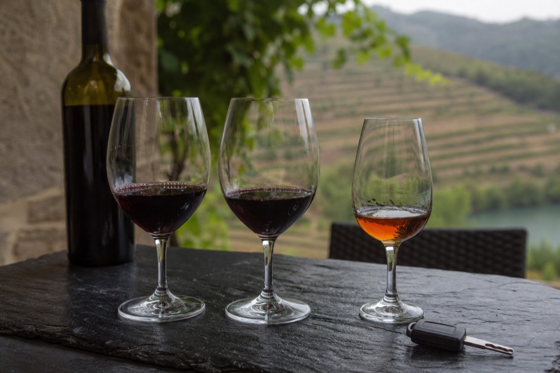 Wine glasses and a car key on a slate tasting table at a Douro quinta, the choice a self-driving visitor faces