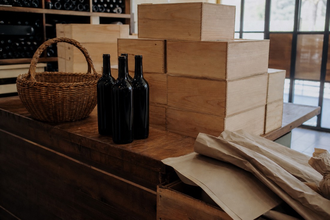 Stacked wooden wine cases and wrapped bottles ready for shipping on a quinta shop counter