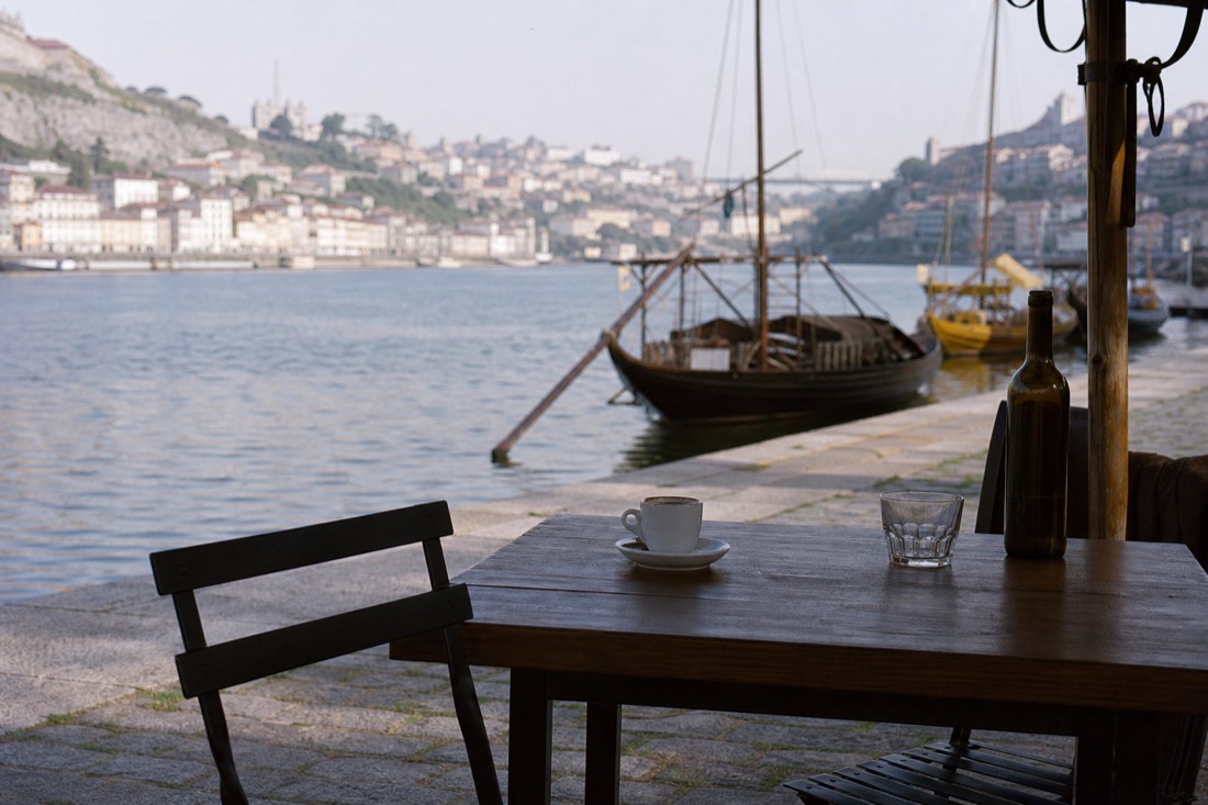 Empty cafe table with coffee overlooking the quiet Pinhão riverfront in the early morning