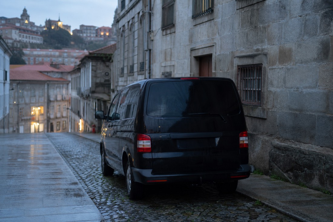 Small tour van waiting on a cobbled Porto street at dawn before the drive to the Douro Valley
