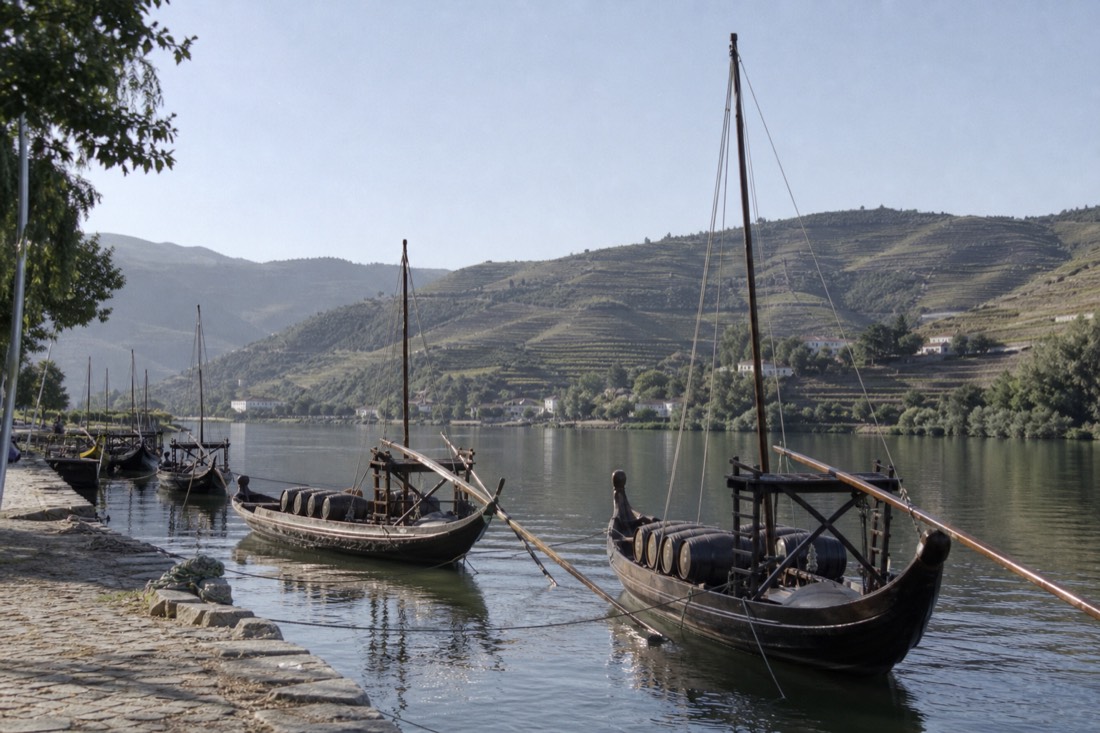 Rabelo boats moored at the Pinhão quay below terraced vineyards, the start of a train-based day in the valley