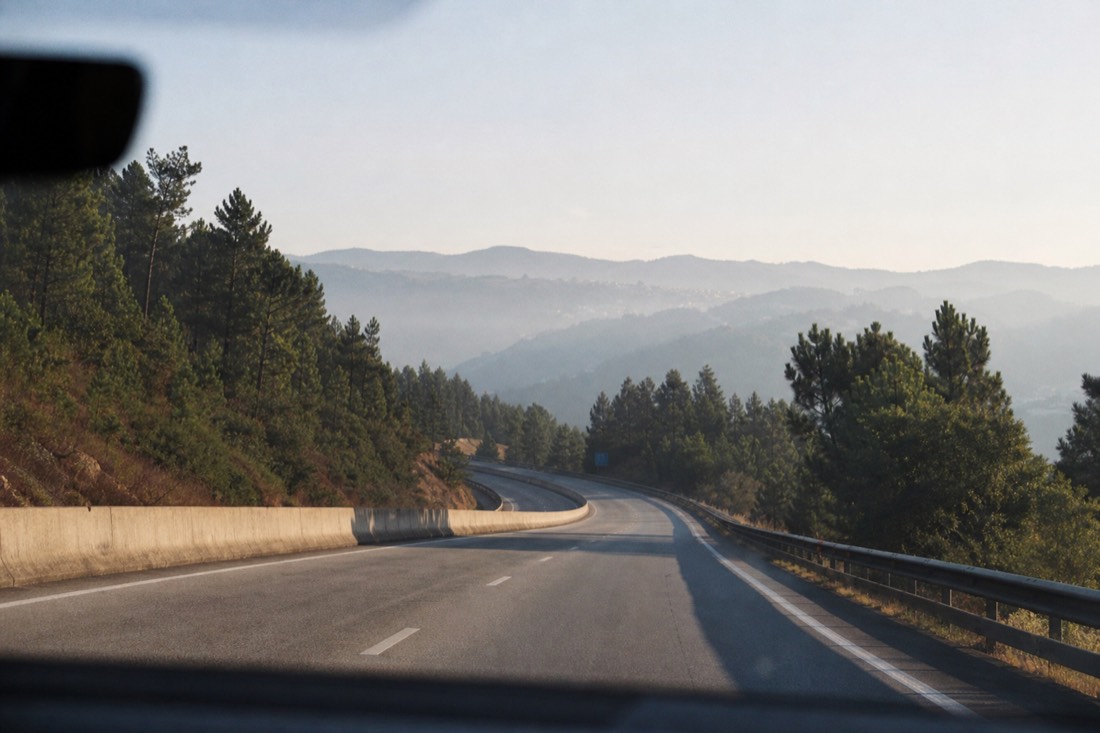 Empty A4 motorway stretch crossing the hills between Porto and the Douro with morning haze