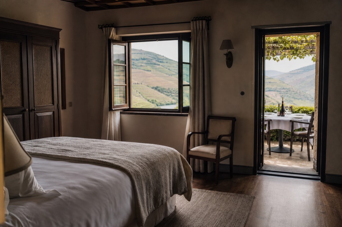 Simple boutique estate room and a dining terrace with an open view over Douro vineyards