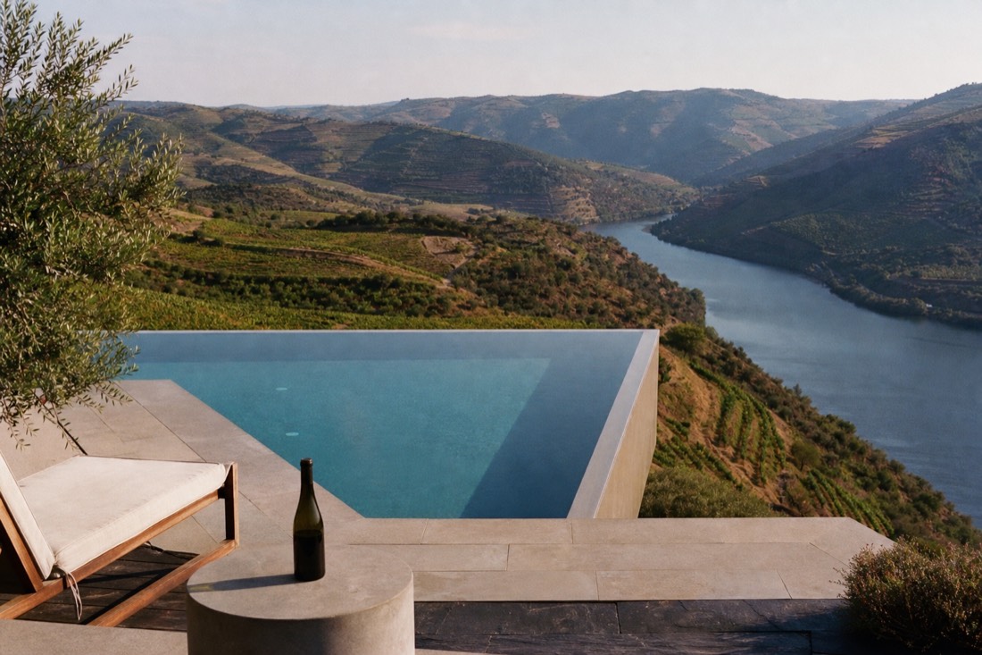 Slim geometric infinity pool on a vineyard terrace with its edge seeming to hover over the valley