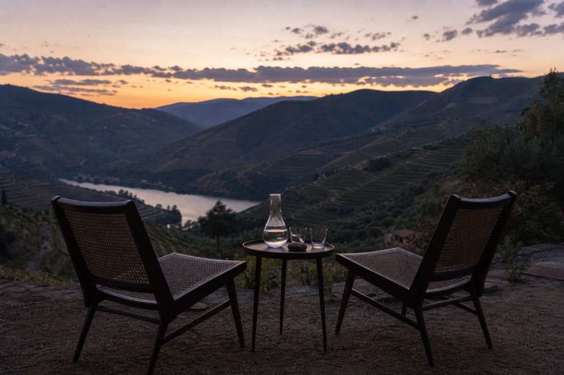 Quinta guest terrace at dusk overlooking dark vineyard terraces, the quiet evening a valley stay buys