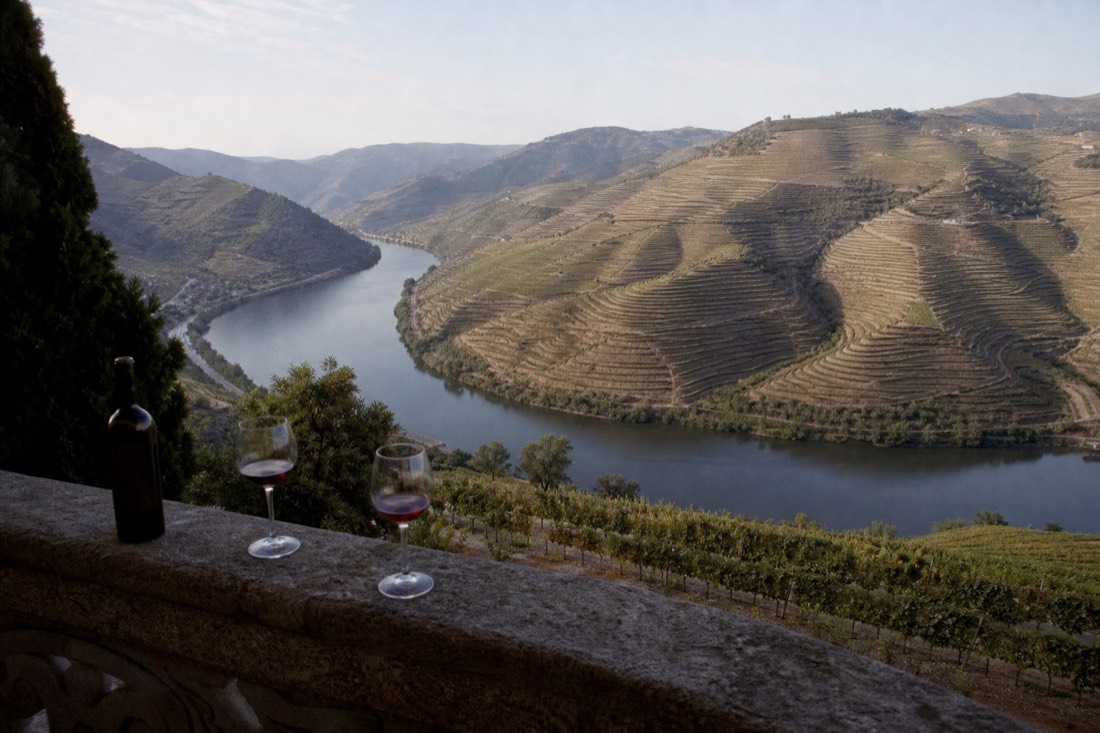 Sweeping view from a high balcony over a horseshoe bend of the Douro ringed by terraces